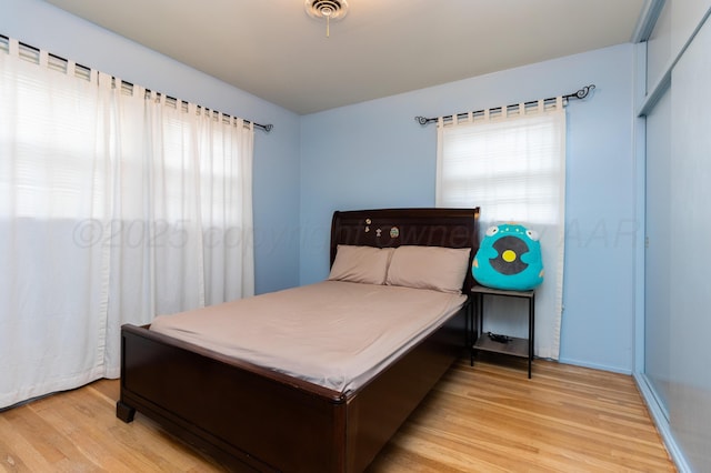 bedroom featuring light wood-style flooring and visible vents
