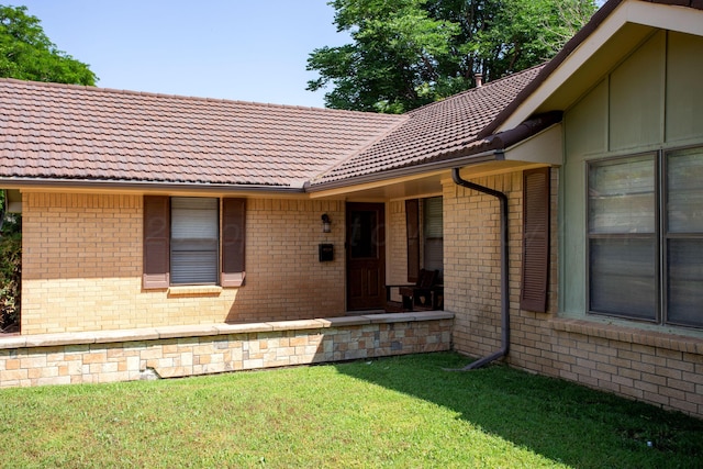 3729 Wayne St, Amarillo, TX 79109 - view of exterior entry with a tile roof, brick siding, and a lawn