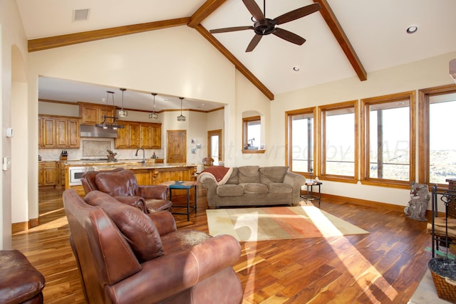 living room featuring visible vents, dark wood-style flooring, beam ceiling, baseboards, and a ceiling fan