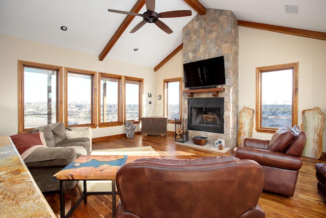 living room featuring ceiling fan, visible vents, a fireplace, wood finished floors, and lofted ceiling with beams