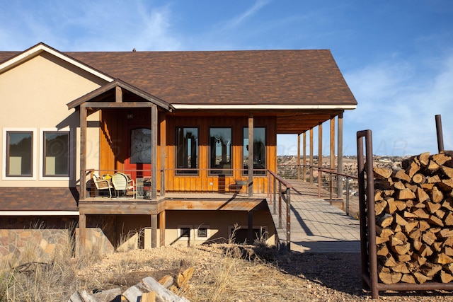 rear view of property featuring roof with shingles