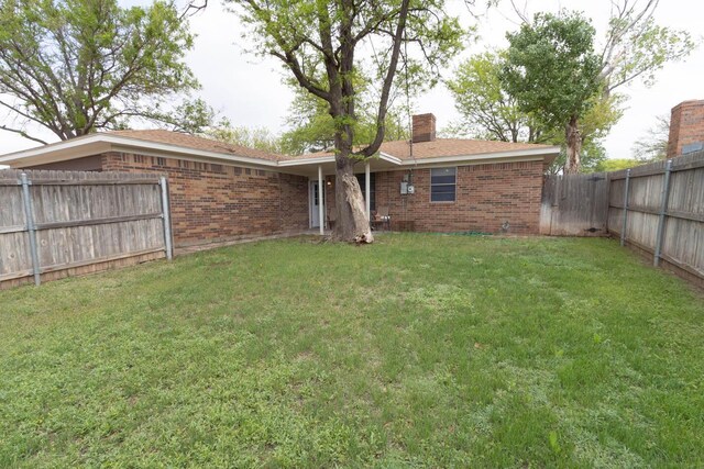 5708 S Fannin St, Amarillo, TX 79110 - rear view of property featuring brick siding, a fenced backyard, and a chimney