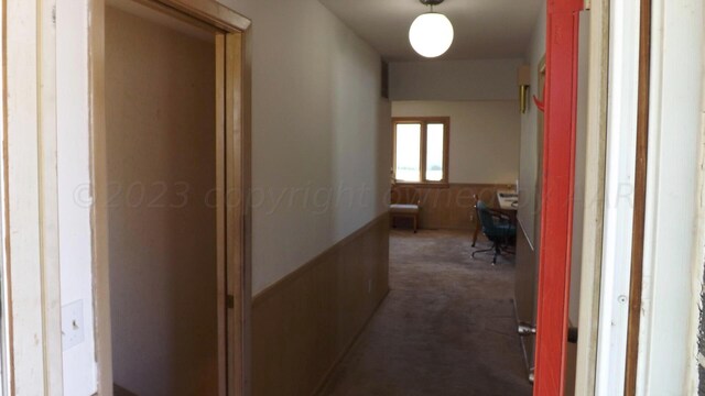 hallway featuring dark colored carpet