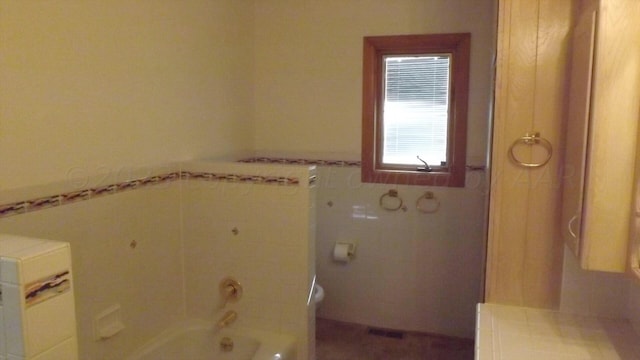 bathroom featuring a tub to relax in and toilet