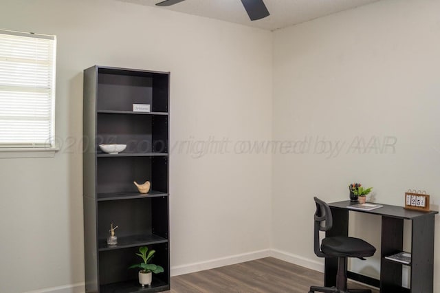 home office featuring dark wood-style flooring, a ceiling fan, and baseboards