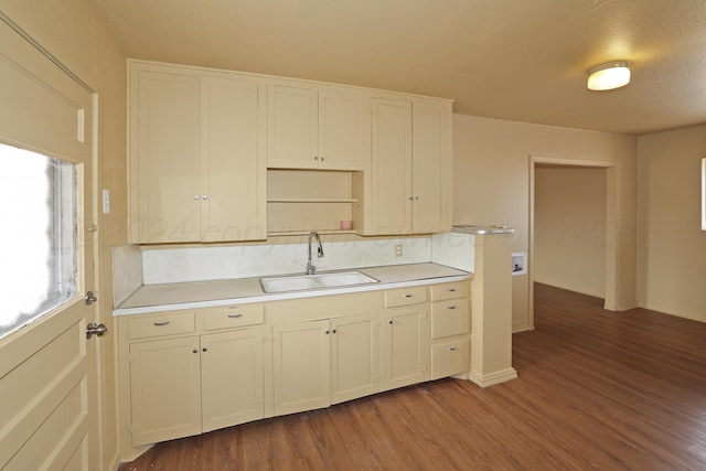 kitchen featuring a textured ceiling, wood-type flooring, and sink