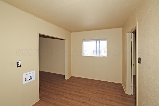 unfurnished bedroom with a closet and dark wood-type flooring