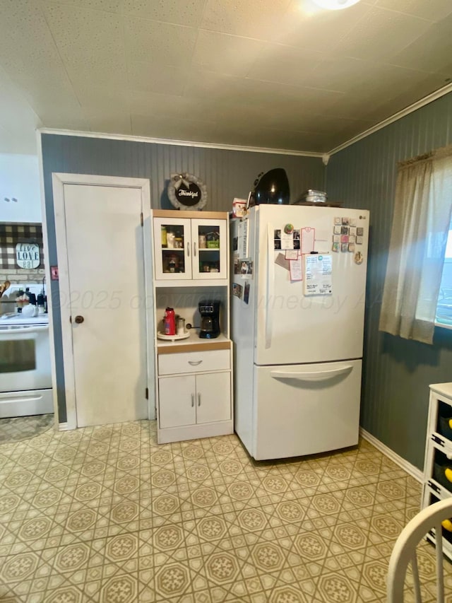 928 Elmore St, Borger, TX 79007 - kitchen featuring white appliances, crown molding, white cabinets, light flooring, and light countertops