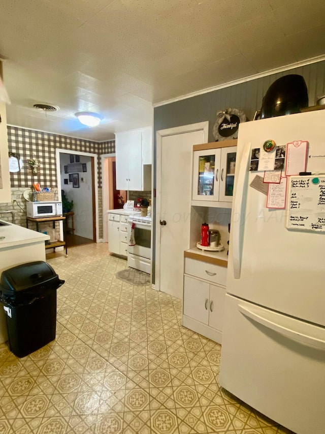 928 Elmore St, Borger, TX 79007 - kitchen with white appliances, white cabinetry, light countertops, light floors, and glass insert cabinets