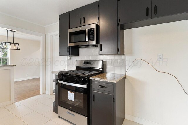 3201 S Grand St, Amarillo, TX 79103 - kitchen featuring stainless steel appliances, decorative backsplash, ornamental molding, dark cabinets, and light stone countertops
