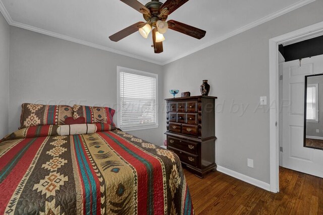 bedroom with crown molding, baseboards, wood finished floors, and multiple windows
