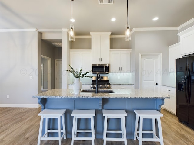 kitchen with a sink, white cabinets, and stainless steel appliances