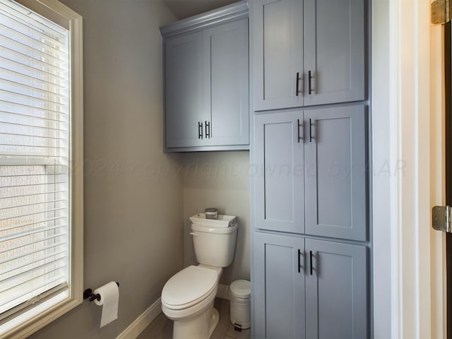 half bathroom with toilet and baseboards