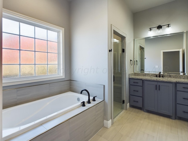 bathroom featuring a bath, a stall shower, and vanity