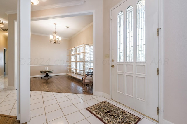 entrance foyer featuring a chandelier, light wood-type flooring, a healthy amount of sunlight, and crown molding