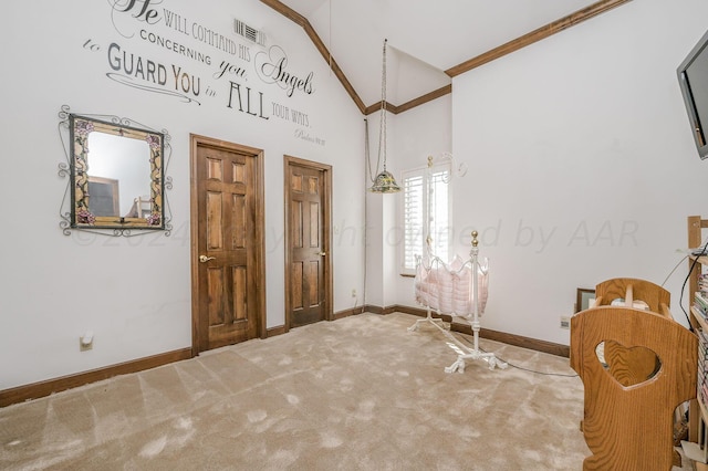 entryway featuring ornamental molding, high vaulted ceiling, and carpet