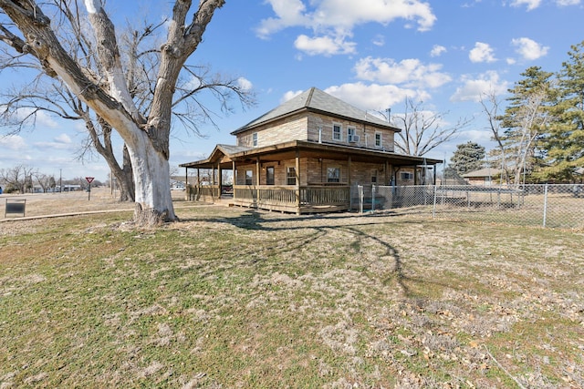 back of property with a lawn and a deck