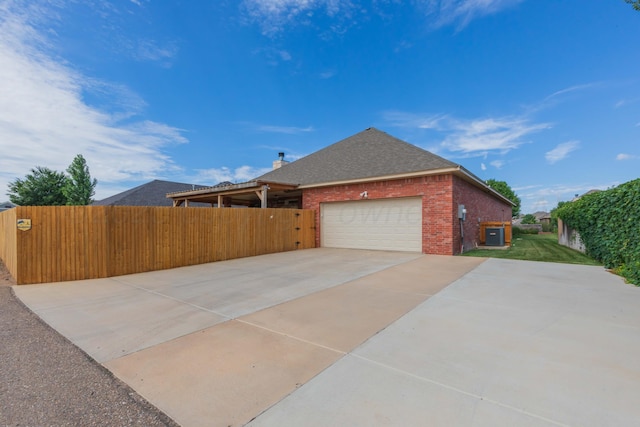 7409 Columbus Dr, Amarillo, TX 79118 - view of home's exterior with an attached garage, concrete driveway, brick siding, and a shingled roof
