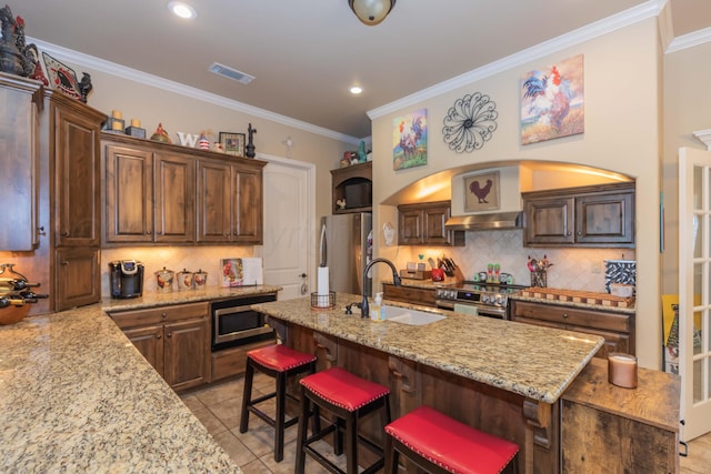 7409 Columbus Dr, Amarillo, TX 79118 - kitchen featuring stainless steel appliances, decorative backsplash, light stone countertops, a kitchen breakfast bar, and ornamental molding