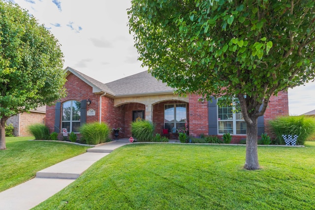 7409 Columbus Dr, Amarillo, TX 79118 - view of front of house with a front yard, brick siding, and a shingled roof