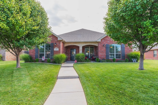 7409 Columbus Dr, Amarillo, TX 79118 - view of front facade with brick siding, a front yard, and roof with shingles