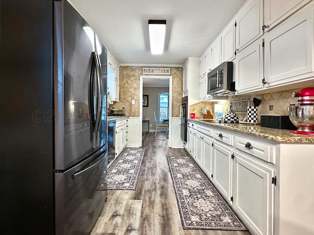 1417 Bluebonnet St, Borger, TX 79007 - kitchen with stainless steel appliances, white cabinets, wood finished floors, and decorative backsplash