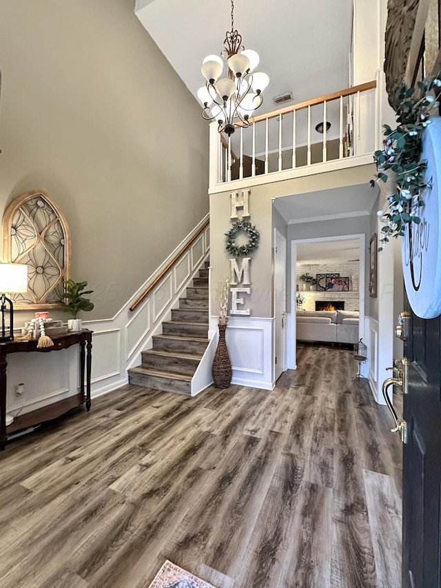 1417 Bluebonnet St, Borger, TX 79007 - foyer with a decorative wall, a towering ceiling, a chandelier, stairway, and wood finished floors