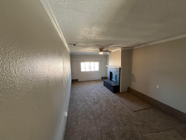 unfurnished living room with crown molding, carpet floors, ceiling fan, a brick fireplace, and a textured ceiling