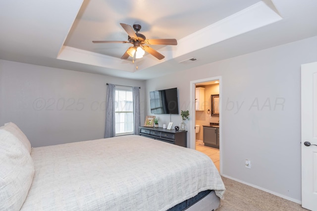 8507 Barstow Dr, Amarillo, TX 79118 - bedroom with a tray ceiling, light colored carpet, connected bathroom, and ceiling fan