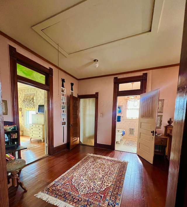 foyer with dark wood-type flooring and ornamental molding