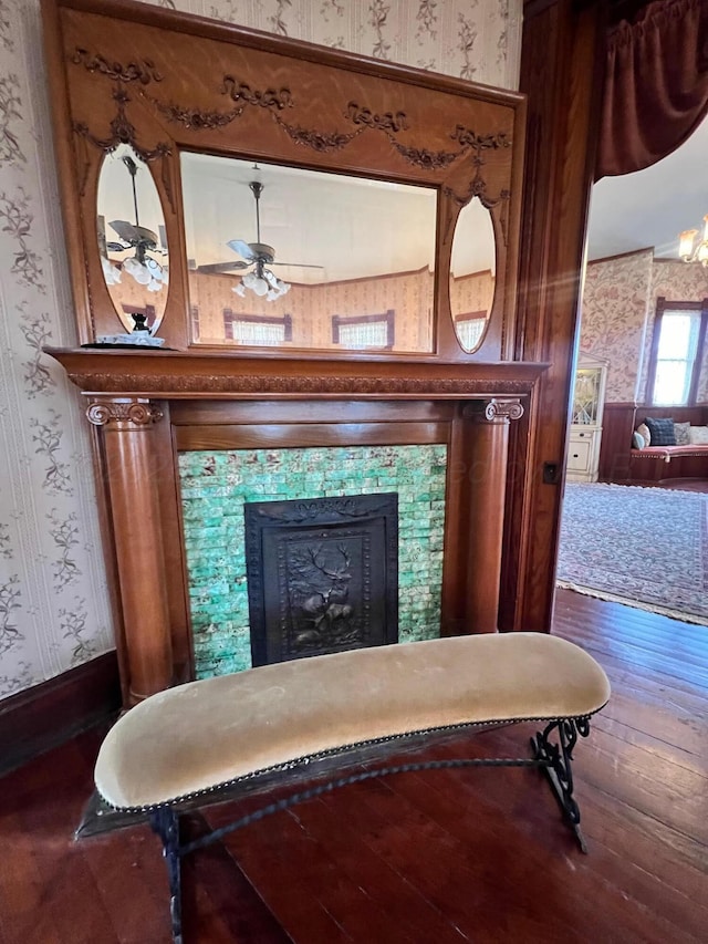 interior space with hardwood / wood-style flooring, ceiling fan, and a tiled fireplace