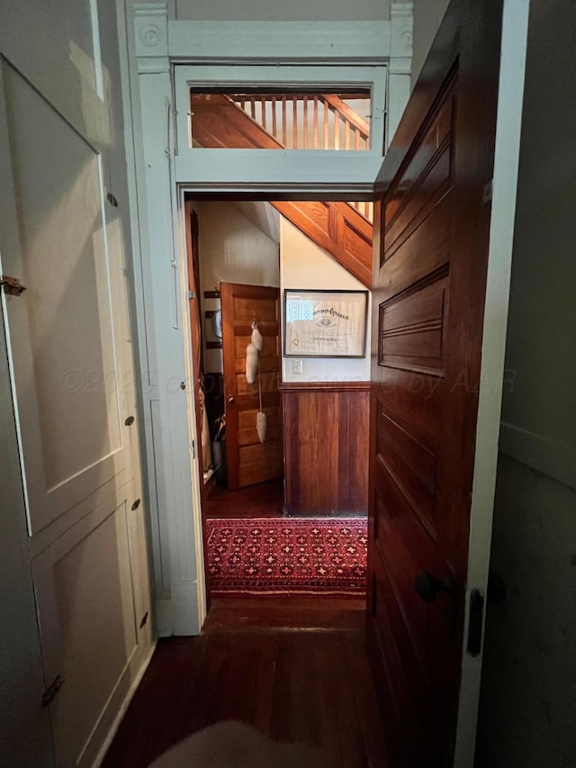 hall featuring hardwood / wood-style floors and wooden walls