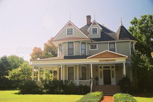 victorian house with a front yard and covered porch