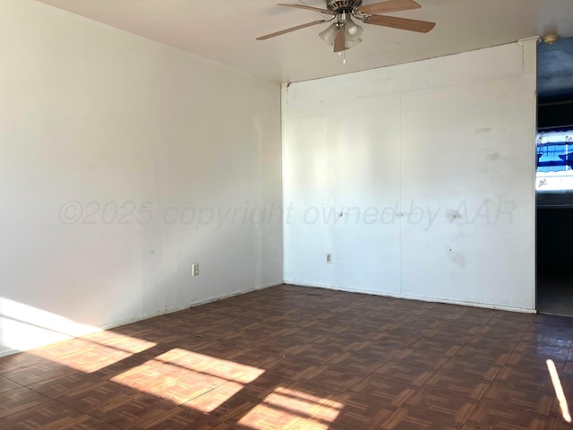 unfurnished room with dark parquet flooring and ceiling fan