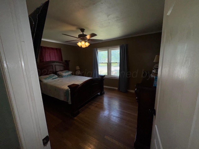 bedroom featuring wood finished floors, crown molding, baseboards, and a ceiling fan