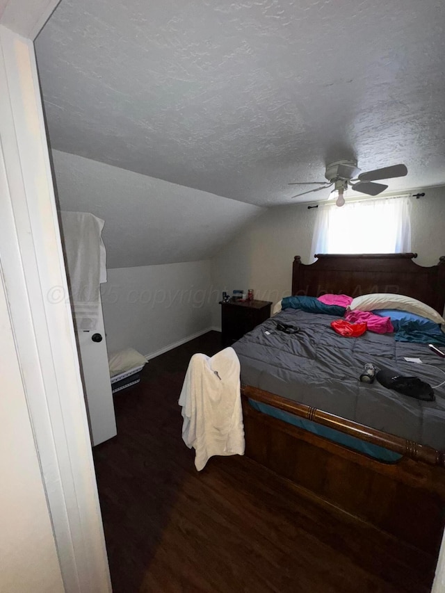 bedroom featuring wood finished floors, lofted ceiling, a textured ceiling, and ceiling fan