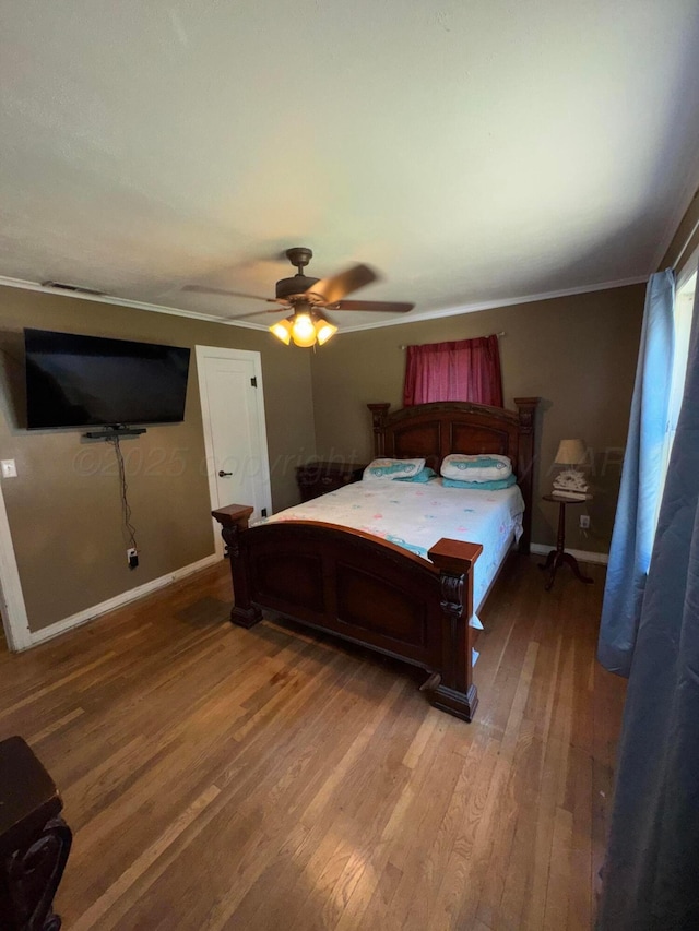 bedroom featuring light wood finished floors, ornamental molding, baseboards, and ceiling fan
