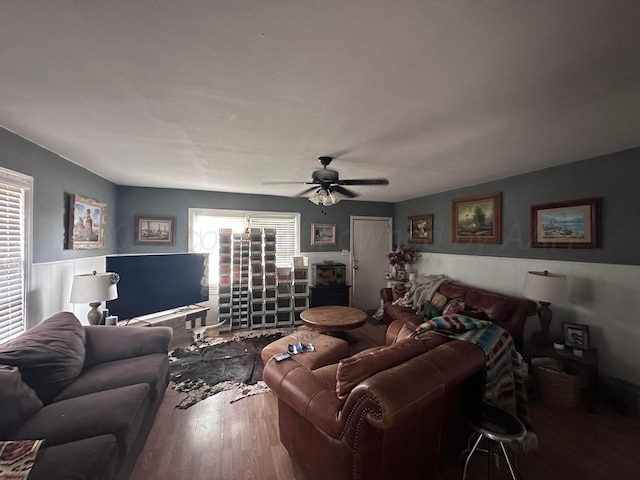 607 N El Paso Ave, Tulia, TX 79088 - living area featuring wood finished floors, plenty of natural light, ceiling fan, and a wainscoted wall