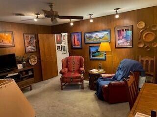 2230 Locust St, Amarillo, TX 79109 - home theater room with ceiling fan, wood walls, and light colored carpet