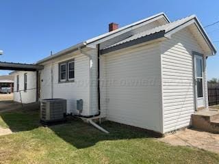 view of property exterior with central air condition unit and a yard