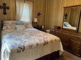 bedroom featuring wooden walls