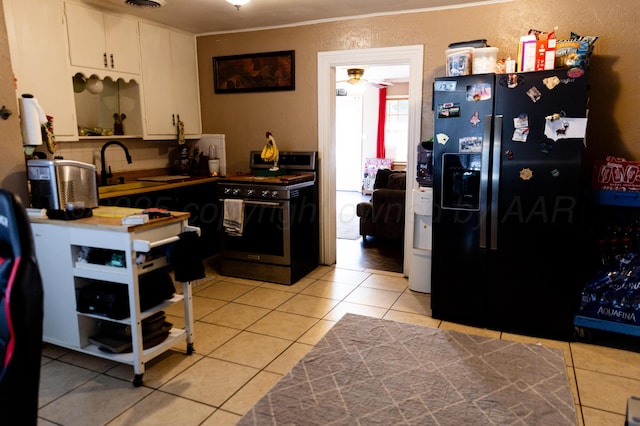 1611 S Palo Duro St, Amarillo, TX 79106 - kitchen featuring black fridge, stainless steel gas stove, light tile patterned floors, white cabinetry, and open shelves