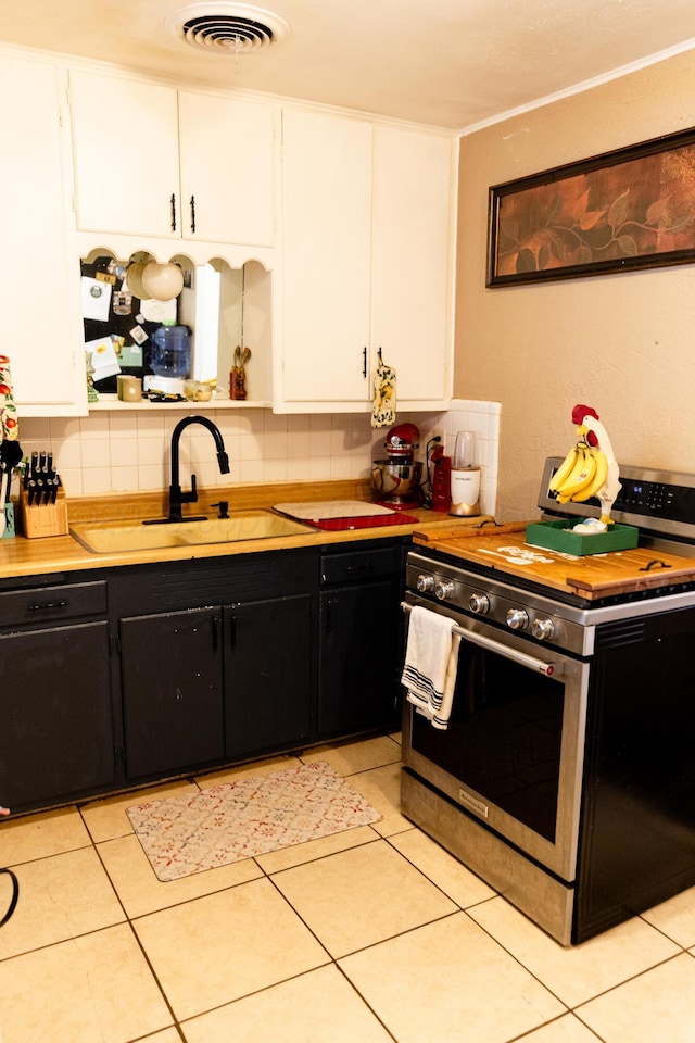 1611 S Palo Duro St, Amarillo, TX 79106 - kitchen featuring stainless steel range oven, dark cabinetry, white cabinets, and tasteful backsplash