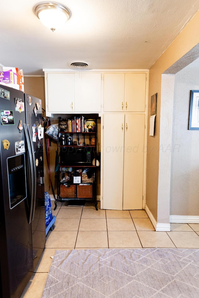 1611 S Palo Duro St, Amarillo, TX 79106 - kitchen featuring black appliances, light tile patterned floors, and white cabinets