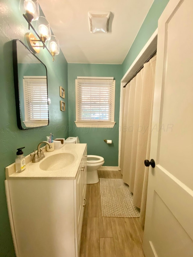 bathroom featuring hardwood / wood-style flooring, vanity, and toilet