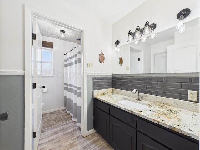 2600 Comanche Trl, Pampa, TX 79065 - full bath featuring wood finished floors, vanity, curtained shower, and decorative backsplash