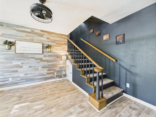 2600 Comanche Trl, Pampa, TX 79065 - staircase featuring wood finished floors, wooden walls, and a textured ceiling