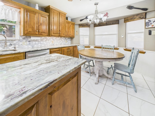 2600 Comanche Trl, Pampa, TX 79065 - kitchen with brown cabinetry, tasteful backsplash, a chandelier, and stainless steel dishwasher