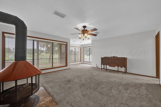 25 Crenshaw St, Amarillo, TX 79124 - sitting room featuring a wood stove, ceiling fan, and carpet flooring