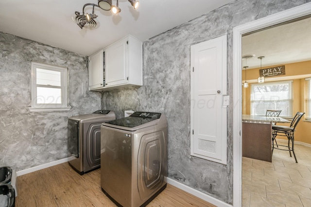washroom with cabinets, washer and clothes dryer, and light wood-type flooring